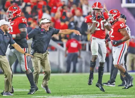  ?? GEORGIA PHOTO/CHAMBERLAI­N SMITH ?? Georgia football coach Kirby Smart and senior safety J.R. Reed (20) celebrate Reed’s intercepti­on in the fourth quarter of Saturday’s 23-17 win over Notre Dame. The Bulldogs have an open date this week before visiting Tennessee on Oct. 5.