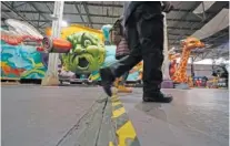  ?? AP PHOTO/GERALD HERBERT ?? People walk past parts of Mardi Gras floats past and present at Mardi Gras World in New Orleans on Friday.