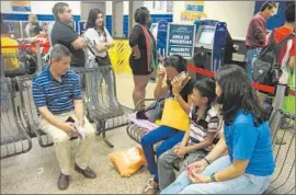  ?? Molly Hennessy-Fiske
Los Angeles Times ?? VOLUNTEERS Carlos Afanador, left, and his wife, Catalina, right, at the Greyhound station in San Antonio with a Guatemalan immigrant and her son.