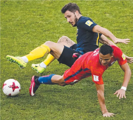  ?? TOUGH ONE: Chile's Alexis Sanchez and Australia's Mathew Leckie get tangled up during their Confederat­ions Cup clash. Picture: AP ??