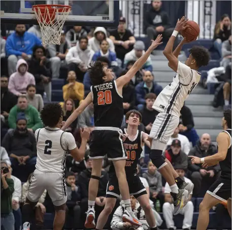  ?? PHOTO BY AMANDA SABGA — MEDIANEWS GROUP/BOSTON HERALD ?? Newton North’s Victor Caira (20) attempts to block a shot from Lawrence’s Igor Gonzalez before a huge crowd Friday night in Lawrence. Newton North advanced with a thrilling 55-54 win.