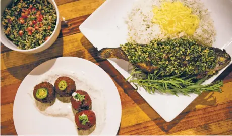  ??  ?? ABOVE: Milad’s quinoa tabouli with pomegranat­e, assorted falafel and a pan-seared stuffed trout with basmati rice.