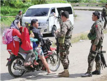  ?? — Reuters ?? Philippine National Police Special Action Force personnel man a checkpoint in Marawi city.