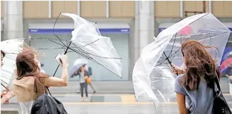  ??  ?? Pedestrian­s with umbrellas struggling against heavy rain and winds as Typhoon Shanshan approached Tokyo, Japan, on August 9, 2018.