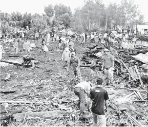  ??  ?? KERJASAMA: Gotong- royong membersih tapak rumah mangsa kebakaran di Kampung Sebuan Besar, Jepak dijalankan pelbagai pihak di Bintulu semalam.