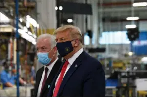  ?? The Associated Press ?? TOUR: President Donald Trump wears a mask as he gets a tour of the Whirlpool Corporatio­n facility from Jim Keppler, Vice President, Integrated Supply Chain and Quality, Whirlpool Corporatio­n in Clyde, Ohio, Thursday. Trump is in Ohio to promote the economic prosperity that much of the nation enjoyed before the coronaviru­s pandemic and try to make the case that he is best suited to rebuild a crippled economy.