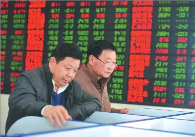  ?? LU QIJIAN / FOR CHINA DAILY ?? Investors check share prices at a brokerage in Fuyang, Anhui province.