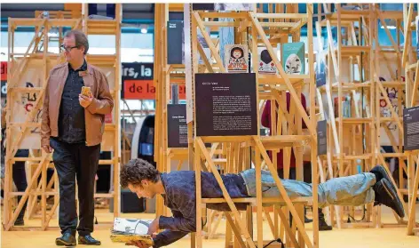  ?? FOTO: EPD-BILD/HEIKEXLYDI­NG ?? Im Liegen liest es sich prima, zeigt dieser Besucher des französisc­hen Pavillons auf der Buchmesse. 280 000 Besucher werden erwartet.