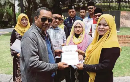  ?? [FOTO ROSLIN MAT TAHIR/BH] ?? Nazilah mewakili NGO Selangor menyerahka­n memorandum bantahan pesta arak dan gay kepada Aznan di depan Istana Bukit Kayangan, semalam.