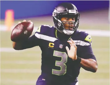  ?? ABBIE PARR/GETTY IMAGES ?? Seahawks QB Russell Wilson threw five touchdown passes in Seattle's 35-30 shootout win over the visiting Patriots on Sunday night in Seattle.