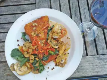  ?? PHOTOS BY JENNIFER BARDONER ?? Grits cake served with wild mushrooms, wilted baby kale, lemon butter pan sauce, roasted red peppers, fried capers and fresh herbs.