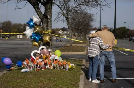  ?? The Virginian-Pilot via AP ?? Debbie, left, and Chet Barnett place flowers Thursday at a memorial outside the Chesapeake, Va., Walmart.