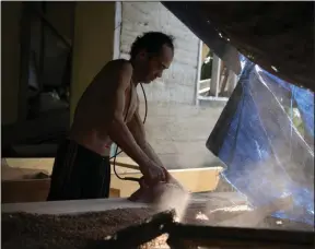  ?? (AP/Dita Alangkara) ?? Jembong, a boat maker, operates an electric planer at his workshop on Karampuang Island, in West Sulawesi, Indonesia, in December.