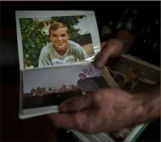  ?? Vadim Ghirda/Associated Press ?? Oleksandr Turovskyi, whose 35-year-old son, Sviatoslav, was among eight men executed in a vacant lot in the suburb of Bucha in March 2022, looks at photos of his son as a young boy at his apartment in Bucha, Ukraine, last month.