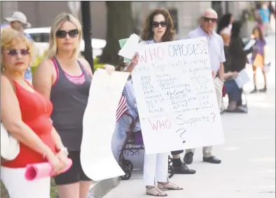  ?? Tyler Sizemore / Hearst Connecticu­t Media ?? Greenwich's Celeste Wilson ( center), an advocate of the anti- Trump group Indivisibl­e Greenwich, protesting the new proposed American Health Care Act in downtown Greenwich in June.