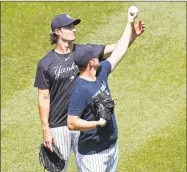  ?? Kathy Willens / Associated Press ?? New York Yankees starting pitcher Gerrit Cole, left, talks to relief pitcher Zack Britton about a grip during a baseball summer training camp workout on Sunday at Yankee Stadium in New York.