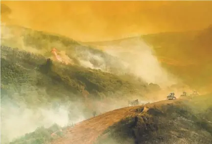  ?? Noah Berger, The Associated Press ?? Bulldozer operators build containmen­t lines while battling the River fire on Tuesday in Lakeport, Calif.