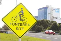  ??  ?? THE FONTERRA Te Rapa plant is seen behind a sign board for cyclists near Hamilton, Aug. 6, 2013.