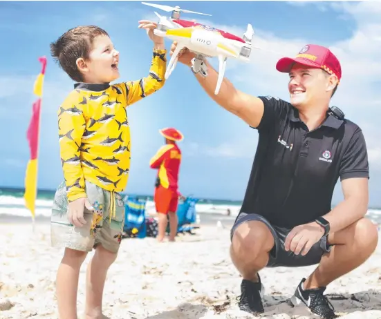  ?? Picture: AAP ?? Westpac Life Saver Rescue Drone operator Jacob Thomson offers Jacob Bryce, 4, a close-up look at one of the drones which will help patrol our beaches.