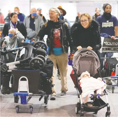  ?? CHRISTINNE MUSCHI / REUTERS ?? Canadians return Monday at Montreal-Trudeau Internatio­nal Airport after being stranded in Morocco due to flight
restrictio­ns that were imposed in an effort to help slow the spread of the novel coronaviru­s disease.