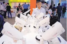  ?? VINCENT YU/ASSOCIATED PRESS ?? A Chinese attendee checks out security cameras at the Global Sources trade fair on April 11. At the Hong Kong event, Chinese manufactur­ers meet with western buyers.