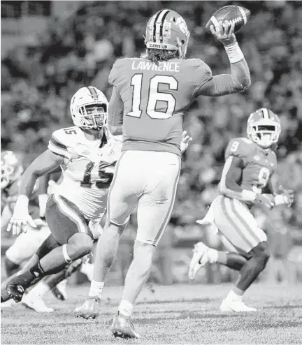  ?? KEN RUINARD/USA TODAY (15) approaches during ?? Clemson QB Trevor Lawrence (16) attempts to throw the ball to running back Travis Etienne (9) as Miami’s Jaelan Phillips Saturday’s game.