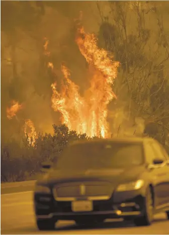  ?? GETTY IMAGES PHOTOS, BELOW RIGHT AND FAR RIGHT; AP PHOTOS ?? BLAZE BATTLE: Firefighte­rs, below, battle wildfires in Los Angeles’ Bel-Air neighborho­od yesterday. Above, a car speeds past the flames in Ventura, Calif.