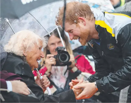  ?? G’DAY: Prince Harry meets 97- year- old Daphne Dunne during a walkabout in heavy rain in Sydney yesterday and ( below) at Circular Quay after taking a boat ride on Sydney Harbour where he watched a sailing display. Prince Harry is in Australia promoting t ??