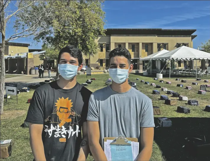  ?? PHOTO ANDY VELEZ ?? IVC students and student employees Jordi Favela (left) and Daniel Lopez stand in front of the backpacks displayed during Thursday’s Send Silence Packing event outside the 2700 Building on campus. The all-day event was intended to advocate suicide prevention and mental health awareness.