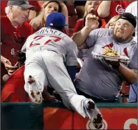  ?? AP/JEFF ROBERSON ?? dives into the stands while chasing a foul ball during the second inning against the St. Louis Cardinals on Monday night in St. Louis. The Cubs defeated the Cardinals 10-2, moving within a victory of clinching their second consecutiv­e division title.