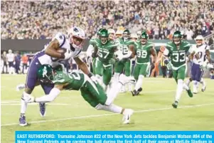  ??  ?? EAST RUTHERFORD: Trumaine Johnson #22 of the New York Jets tackles Benjamin Watson #84 of the New England Patriots as he carries the ball during the first half of their game at MetLife Stadium in East Rutherford, New Jersey. — AFP