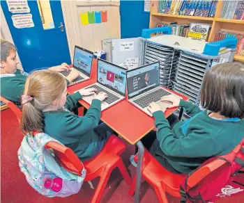  ?? ?? DIGITAL WORLD: Children make use of laptops as part of a national programme to expand internet access in schools. Picture by Kim Cessford.