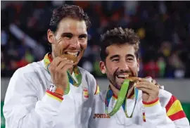  ??  ?? Rafael Nadal, left, and Marc Lopez, of Spain, celebrate after winning the gold medal in men's doubles