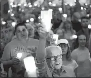  ??  ?? A Riverfront Park candleligh­t vigil protests the Trump administra­tion’s collusion with Sinclair Broadcasti­ng to blame the fluctuatin­g weather on Mexico.