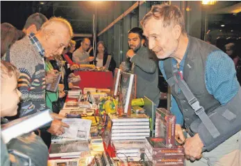  ?? FOTO: C. STECKELER ?? Am Ende der Multivisio­ns-Show „Nepal – Acht, der Weg hat ein Ziel“, war der Bücherstan­d von Dieter Glogowski dicht umdrängt, hatten die Besucher noch zahlreiche Fragen an den Fotojourna­listen.