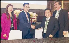  ??  ?? BPI and PGBI executives seal the agreement to help create more green buildings with a handshake and a MOU. Photo shows (from left) BPI vice president for sustainabl­e energy finance Jo Ann Eala, BPI senior vice president for Corporate Credit Products...