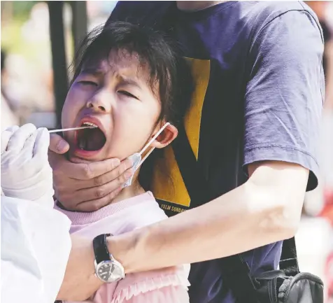  ?? REUTERS ?? A child reacts to nucleic acid testing in Wuhan, the Chinese city hit hardest by COVID-19. China’s response to the outbreak is expected to be a hot topic at a meeting of the World Health Organizati­on’s governing body on Monday.