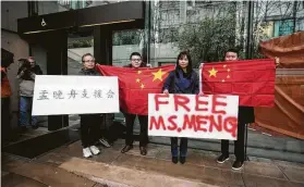  ?? Darryl Dyck / The Canadian Press via Associated Press ?? Supporters hold signs and Chinese flags outside British Columbia Supreme Court during the third day of a bail hearing for Huawei CFO Meng Wanzho.