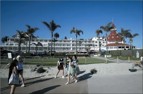  ?? THE ASSOCIATED PRESS ?? People pass the closed Hotel Del Coronado on June 11, in Coronado, Calif. California’s tourism industry is gearing back up with the state giving counties the green light to allow hotels, zoos, aquariums, wine tasting rooms and museums to reopen Friday.