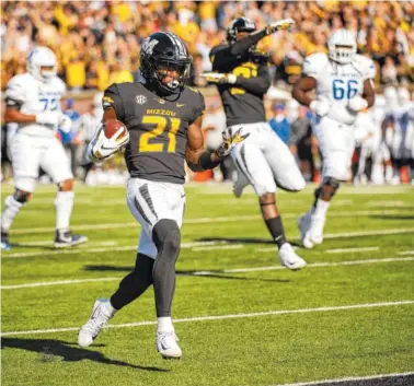  ?? AP PHOTO/L.G. PATTERSON ?? Missouri defensive back Christian Holmes returns an intercepti­on for a touchdown during the first half Saturday against Memphis in Columbia, Mo. Missouri rolled to a 65-33 victory over Memphis.