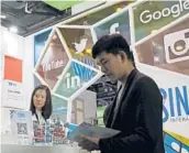  ?? ANDY WONG/AP 2016 ?? A visitor seeks informatio­n at a social network company booth in Beijing. LinkedIn plans to pull access in China, replacing posts with a jobs listing site.