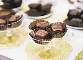  ??  ?? Top: Ed Lew selects a chocolate sample offered by Jeannie Jew at See's in Stonestown Galleria. Above: See’s chocolate truffles are a company classic.