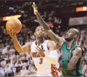  ?? Rhona Wise
European Pressphoto Agency ?? DWYANE WADE, guarded by Kevin Garnett, had two points in the first half but finished with 23.