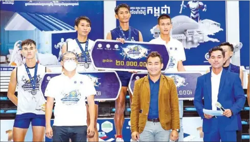  ?? SUPPLIED ?? Duk (centre) is presented with the prize money banner after his team won in the final of the Volleyball Emperors on April 29.