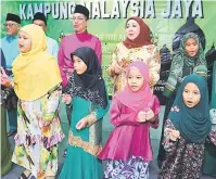  ??  ?? GEMBIRA: Fadillah dan Hasidah menyanyika­n lagu raya bersama kanak-kanak dari Kampung Malaysia Jaya pada Majlis Ramah Tamah-Aidilfitri malam kelmarin.