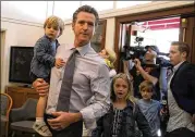  ?? JUSTIN SULLIVAN / GETTY IMAGES ?? Democratic gubernator­ial candidate Lt. Gov. Gavin Newsom, with his kids Dutch (left), Montana and Hunter, prepares to vote Tuesday in Larkspur, California. He was expected to claim the top spot in the state’s gubernator­ial primary.