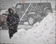  ?? MARSHALL GORBY / STAFF ?? Snow piles up as a man waits for the bus Saturday on Woodman Avenue.