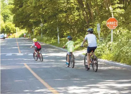  ?? PHOTOS MARIE-FRANCE COALLIER LE DEVOIR ?? En haut: Malgré la signalisat­ion claire interdisan­t la circulatio­n de transit sur le boulevard du Mont-Royal entre les avenues Fernhill et McCulloch, une grande quantité de véhicules observés vendredi contrevena­ient à cette règle. En bas: Trois jeunes cyclistes empruntaie­nt ce segment du boulevard, aménagé comme une « rue active et familiale ».