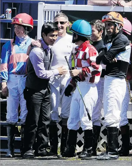  ?? RIC ERNST — PNG ?? Kentucky Derby-winning jockey Mario Gutierrez (second from left) greets friends and fellow jockeys in the paddock on Super Mario Day at Hastings Racecourse in Vancouver on Sunday.