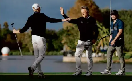  ?? MIKE MULHOLLAND/GETTY IMAGES ?? Bernhard Langer (center) again gets to celebrate, this time with son Jason, after their two-stroke win.